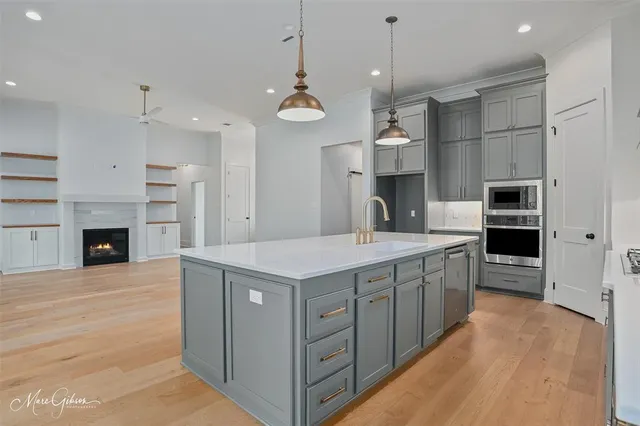 a large kitchen with stainless steel appliances granite countertop a stove and a kitchen island