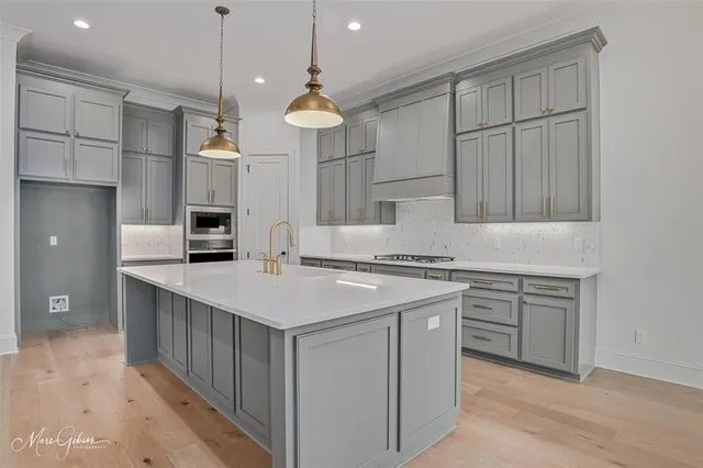 a kitchen that has a lot of cabinets in it and white stainless steel appliances