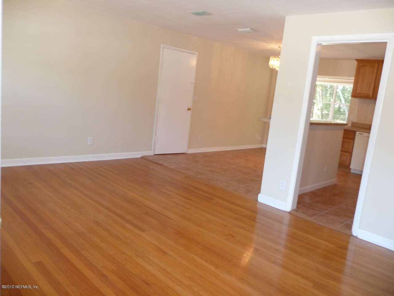 3384 Rogero Road Jacksonville, FL 32277 - Photo 3 of 17 an empty room with wooden floor and windows
