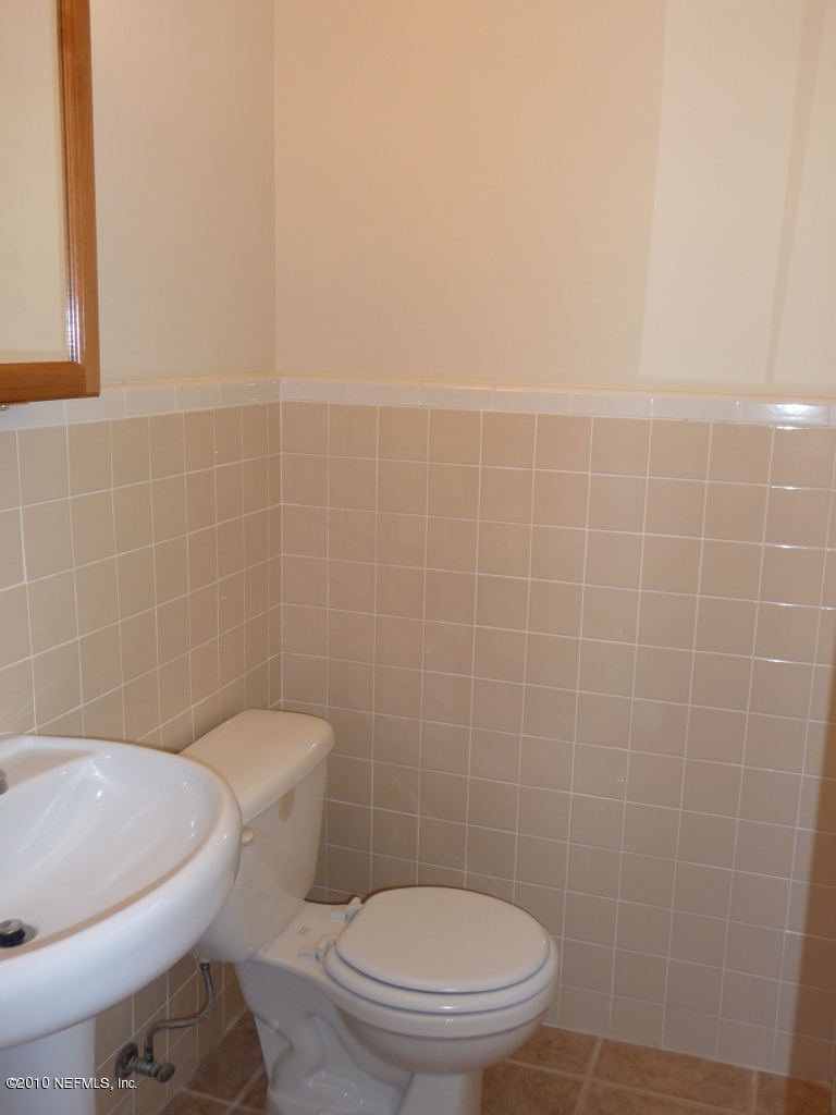 3384 Rogero Road Jacksonville, FL 32277 - Photo 10 of 17 a white toilet sitting next to a bath tub