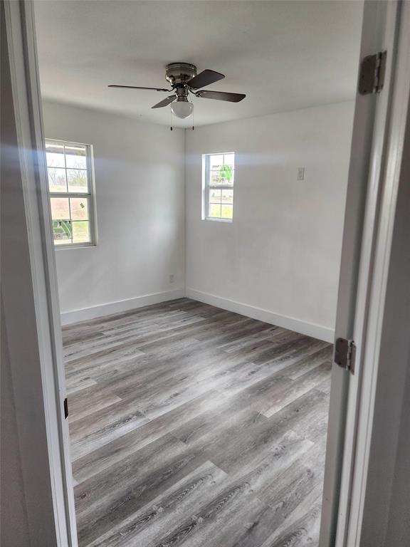 1178 Nob Hill Road Quinlan, TX 75474 - Photo 3 of 13 Empty room featuring wood finished floors, ceiling fan, and baseboards
