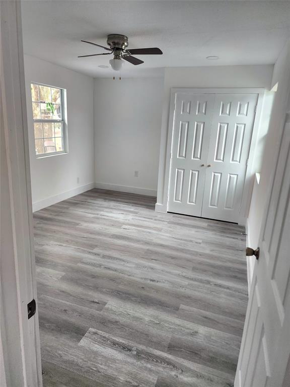 1178 Nob Hill Road Quinlan, TX 75474 - Photo 4 of 13 Unfurnished bedroom with baseboards, wood finished floors, a ceiling fan, and a closet