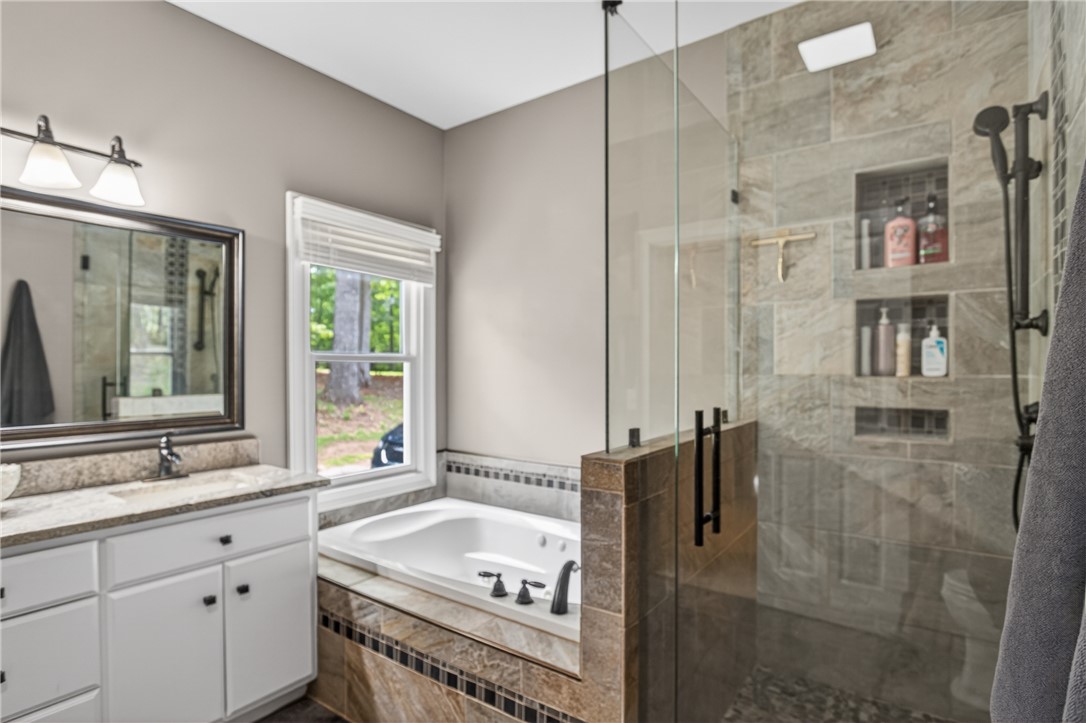 136 Loran Pointe Circle Seneca, SC 29672 - Photo 20 of 50 Luxurious bathroom retreat, featuring a spacious soaking tub, elegant tile work, and a modern walk-in shower.