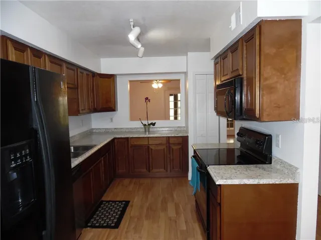 a kitchen with stainless steel appliances granite countertop a refrigerator a stove top oven a sink and dishwasher