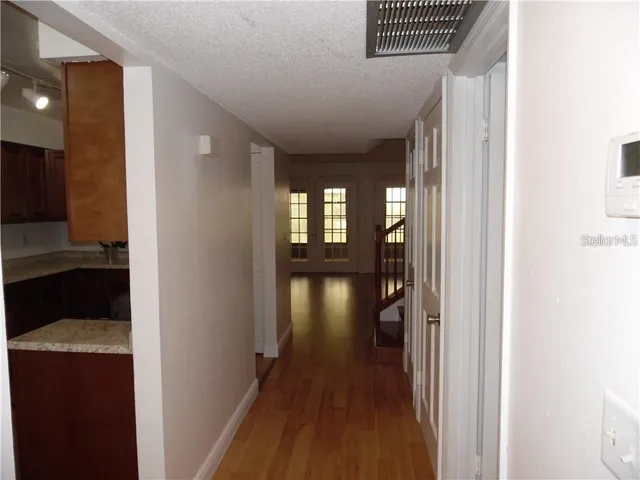a view of hallway with livingroom and wooden floor