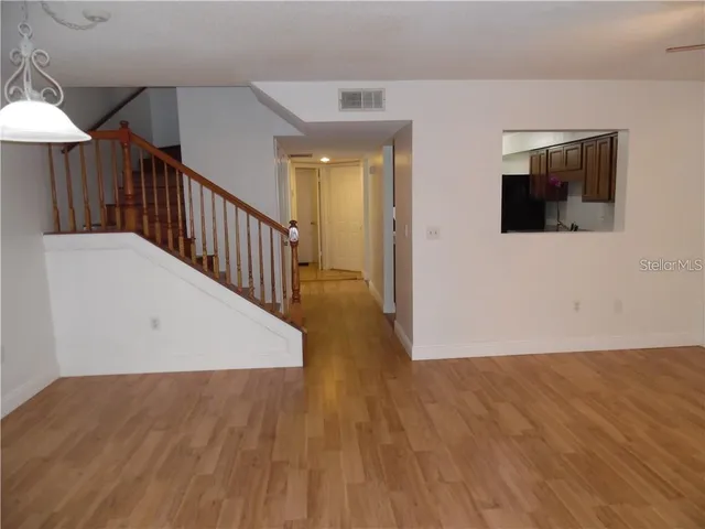 a view of a hallway with wooden floor and staircase