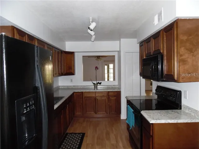 a kitchen with stainless steel appliances granite countertop a refrigerator a stove top oven a sink and dishwasher