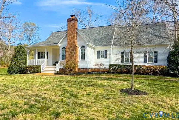 a house that has a big yard with plants and large trees
