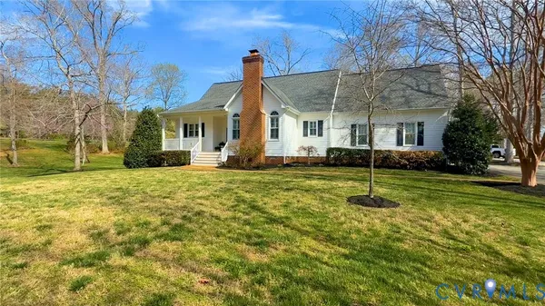 a view of a yard in front of a house with a large tree