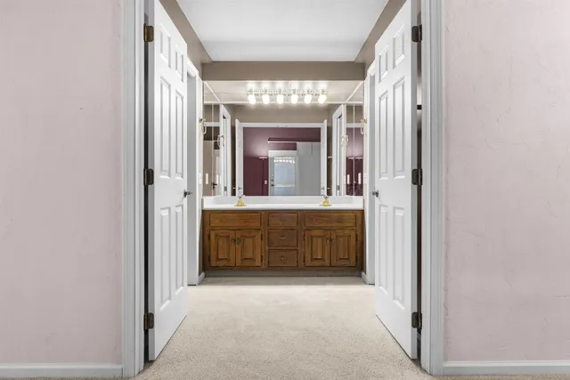 a bathroom with a double vanity sink mirror and a bathtub