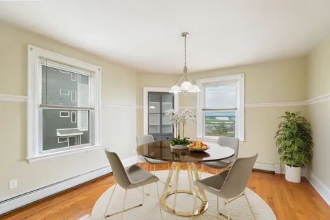 a view of an empty room with window and wooden floor