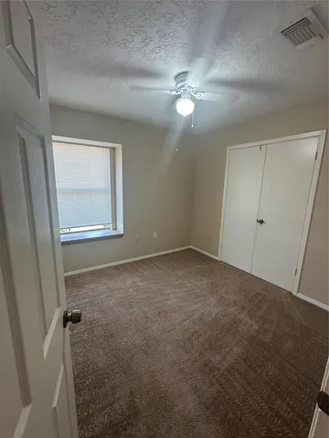 en empty room with windows and fan