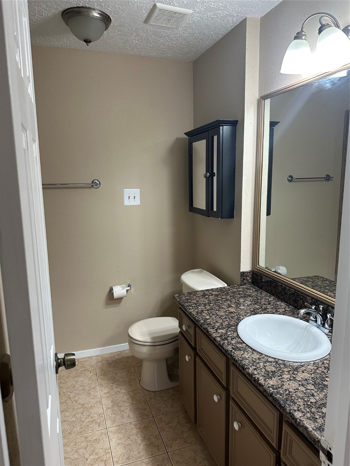 4727 Roserock Lane Spring, TX 77388 - Photo 9 of 14 a bathroom with a granite countertop sink a toilet a mirror and shower