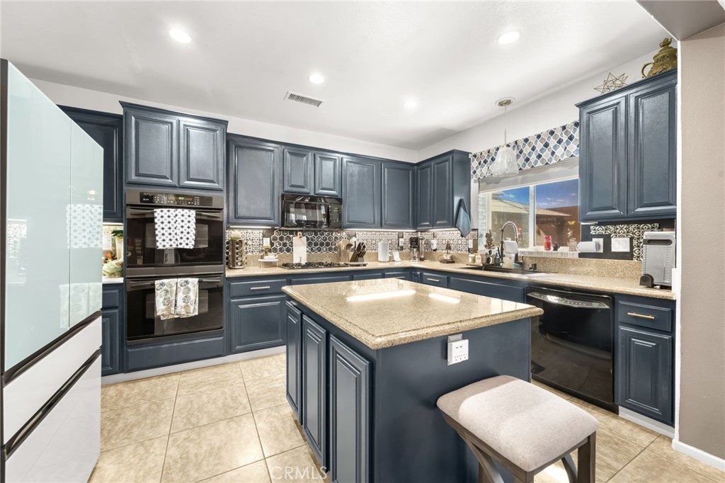 38327 Rancho Vista Drive Beaumont, CA 92223 - Photo 16 of 48 a kitchen with stainless steel appliances granite countertop a sink stove refrigerator and cabinets