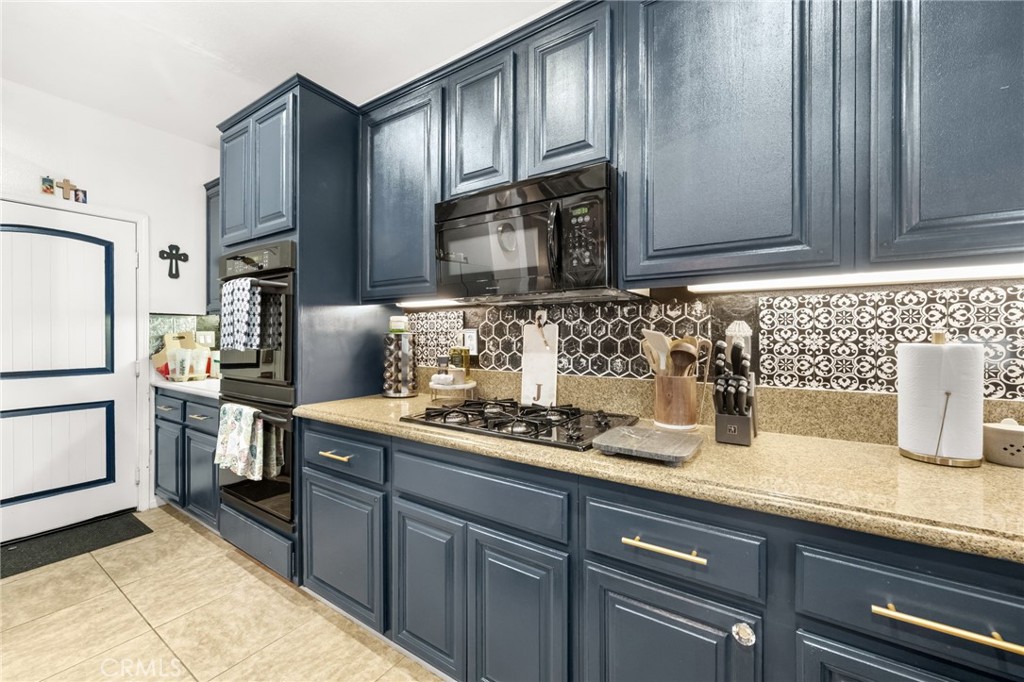 38327 Rancho Vista Drive Beaumont, CA 92223 - Photo 17 of 48 a kitchen with stainless steel appliances granite countertop a sink stove and refrigerator