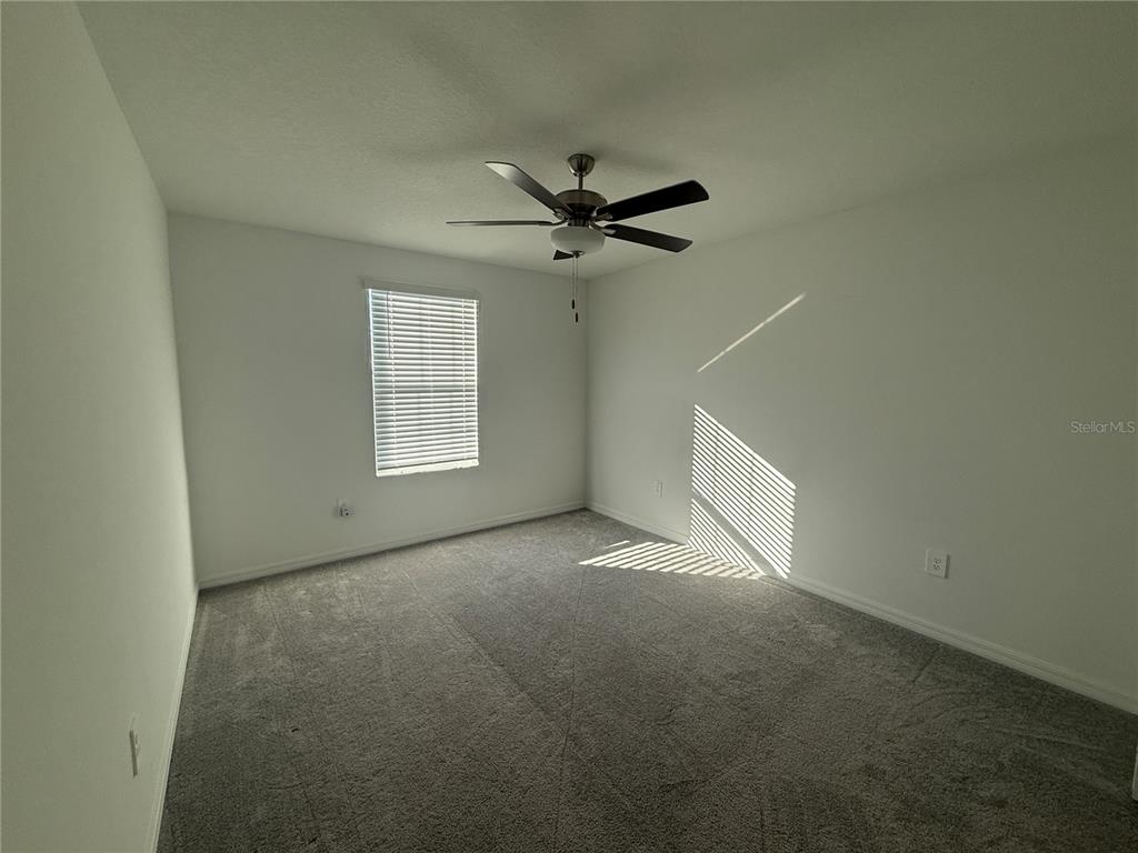 2881 Silver Scallop Loop Wimauma, FL 33598 - Photo 13 of 17 an empty room with windows and fan