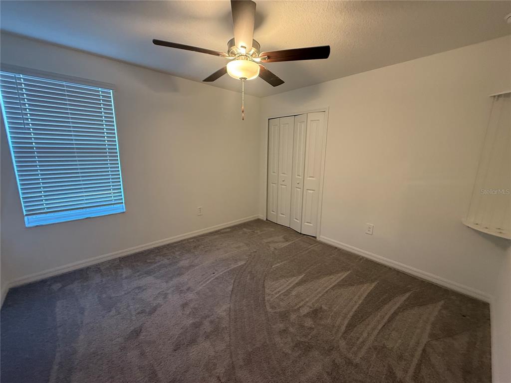 2881 Silver Scallop Loop Wimauma, FL 33598 - Photo 15 of 17 a view of a room with a ceiling fan and a window