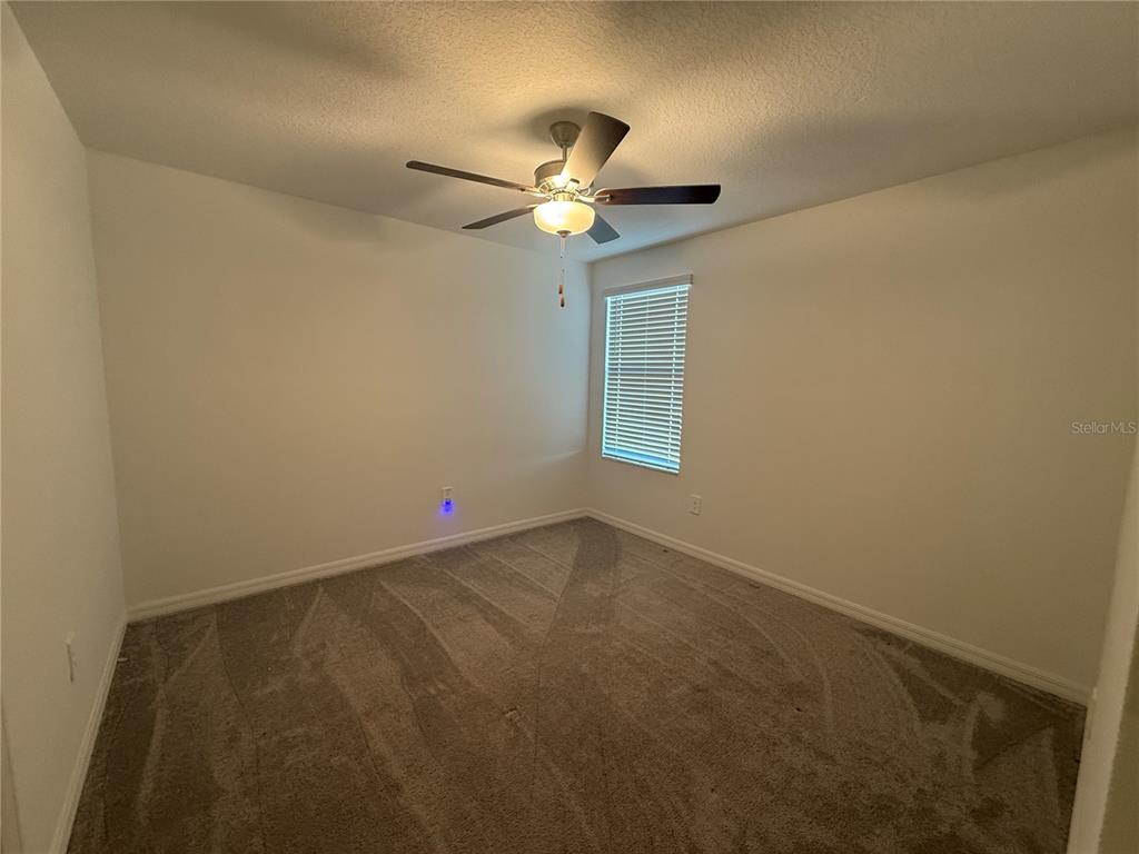 2881 Silver Scallop Loop Wimauma, FL 33598 - Photo 16 of 17 an empty room with windows and fan