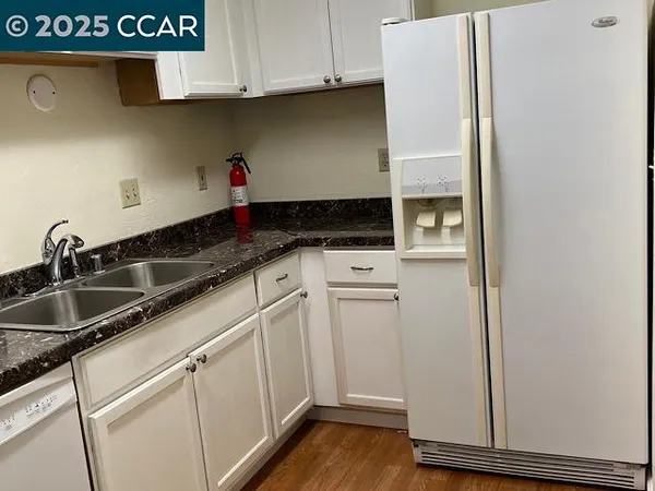 a kitchen with granite countertop a sink and cabinets