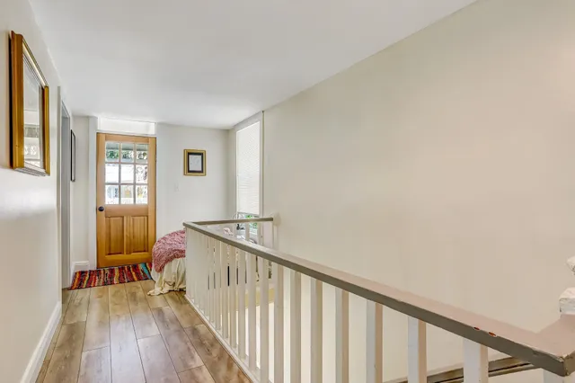 a view of a hallway with wooden floor and a living room