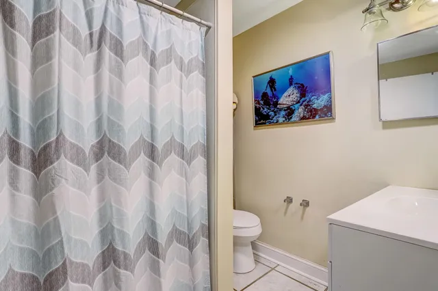 a bathroom with a toilet and a shower curtain