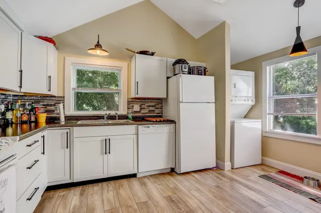a kitchen with white cabinets and white appliances