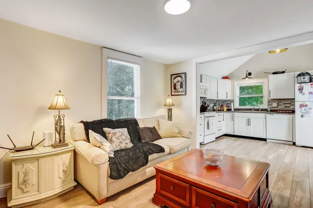 a living room with furniture and kitchen view