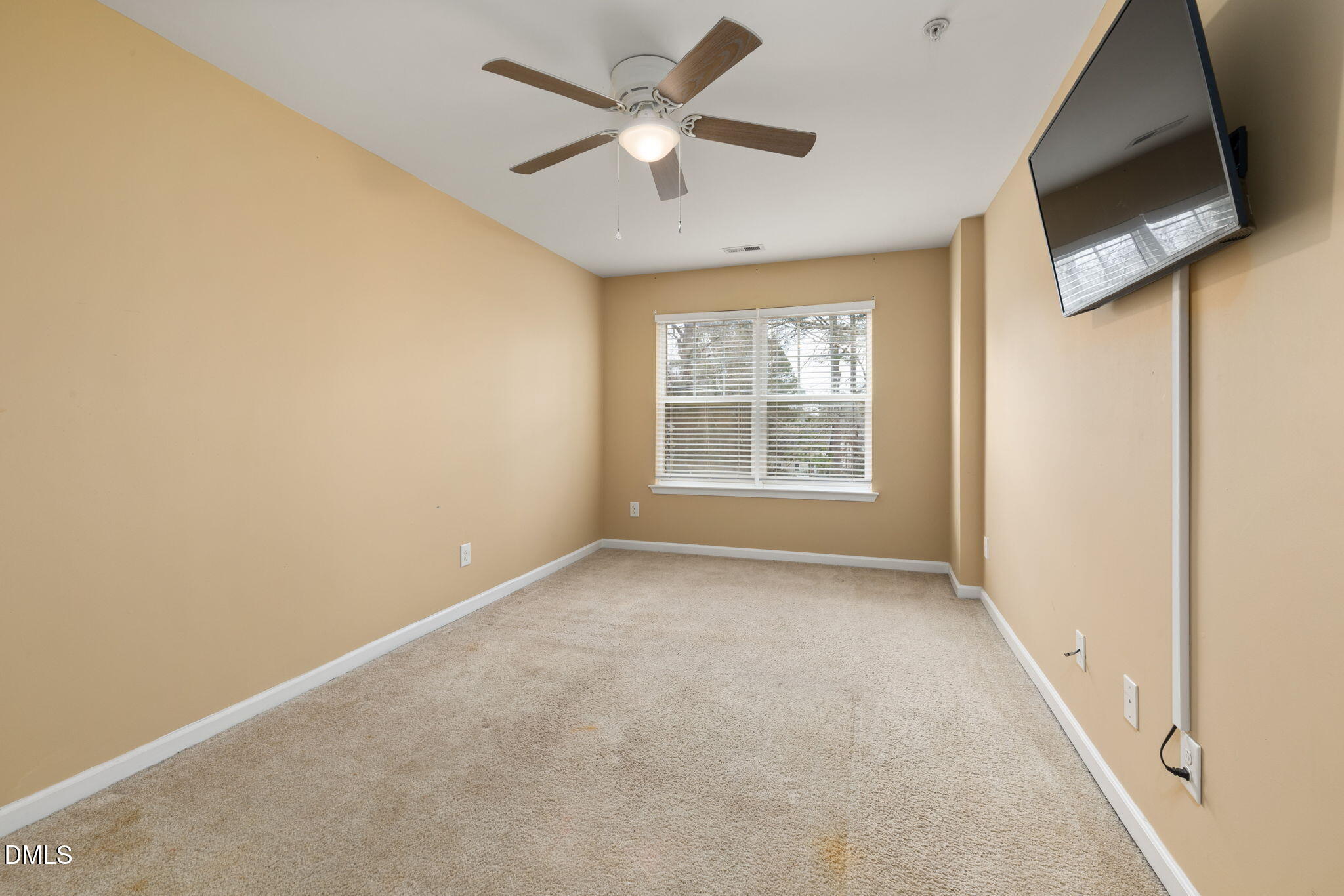 401 Coalinga Lane, Unit 108 Raleigh, NC 27610 - Photo 15 of 28 an empty room with windows and a ceiling fan