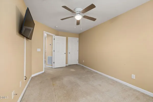 an empty room with windows and a ceiling fan