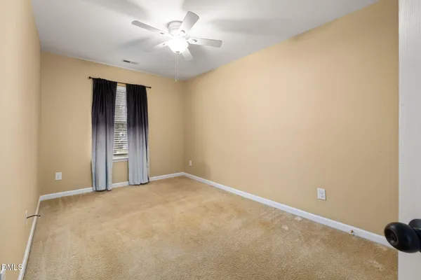 an empty room with a ceiling fan and a window