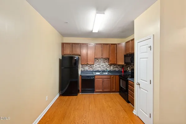 a kitchen with stainless steel appliances granite countertop a refrigerator and a stove