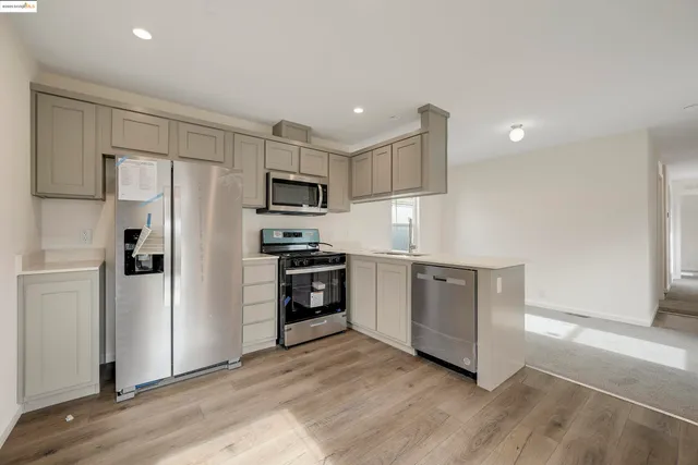 a kitchen with white cabinets and stainless steel appliances