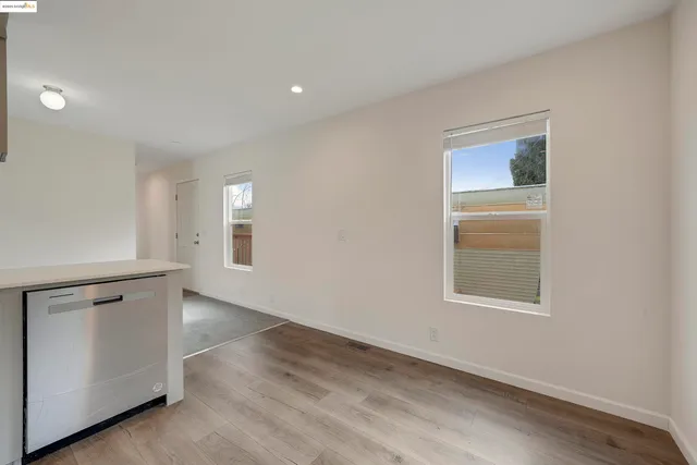 an empty room with a window and wooden floor