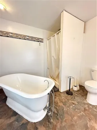 an empty room with windows and ceiling fan