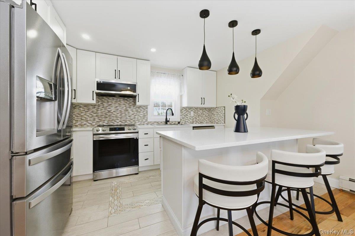 66 Elm Street Valley Stream, NY 11580 - Photo 14 of 23 a kitchen with stainless steel appliances a stove a sink and a refrigerator