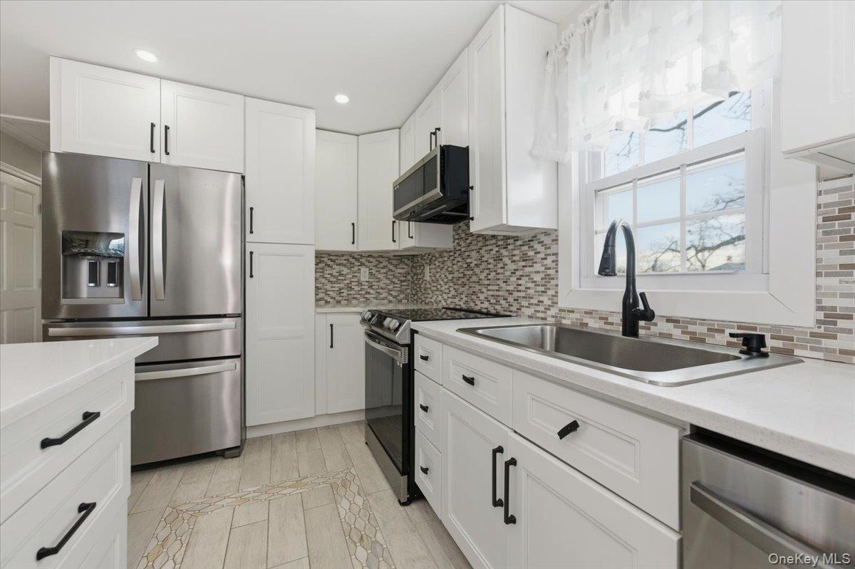 66 Elm Street Valley Stream, NY 11580 - Photo 15 of 23 a kitchen with stainless steel appliances a sink stove and refrigerator