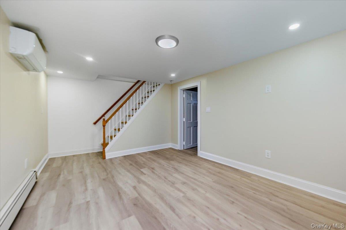 66 Elm Street Valley Stream, NY 11580 - Photo 18 of 23 a view of an empty room with wooden floor and stairs