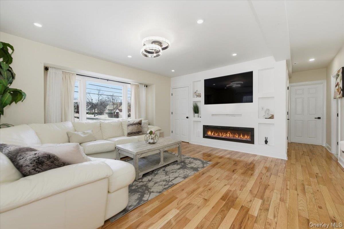 66 Elm Street Valley Stream, NY 11580 - Photo 3 of 23 a living room with furniture a fireplace and a flat screen tv
