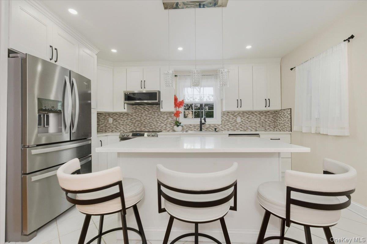 66 Elm Street Valley Stream, NY 11580 - Photo 4 of 23 a kitchen with stainless steel appliances a sink and a refrigerator