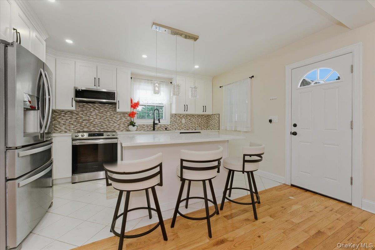 66 Elm Street Valley Stream, NY 11580 - Photo 5 of 23 a kitchen with stainless steel appliances a stove a sink refrigerator and a microwave