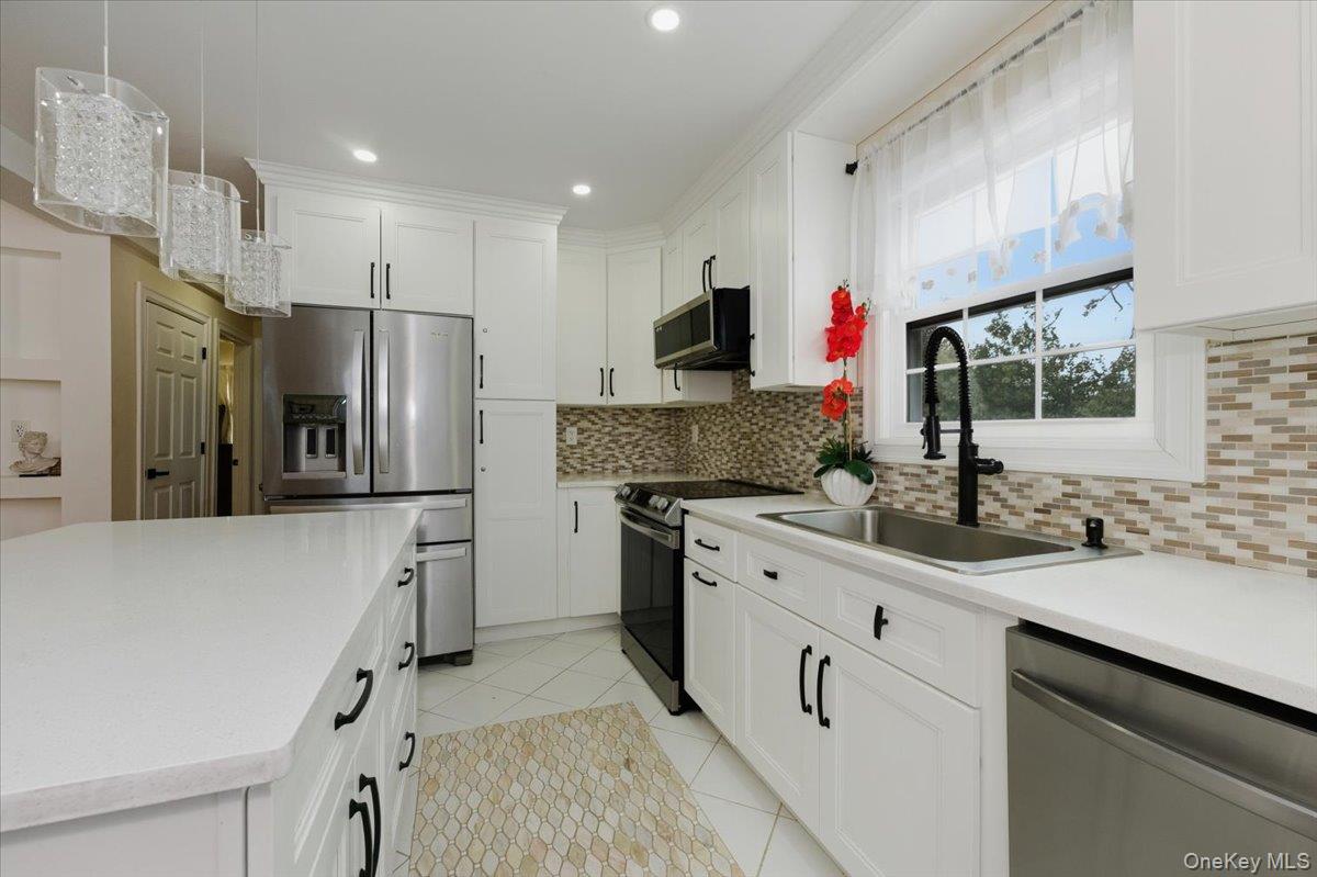 66 Elm Street Valley Stream, NY 11580 - Photo 6 of 23 a kitchen with a sink refrigerator and microwave