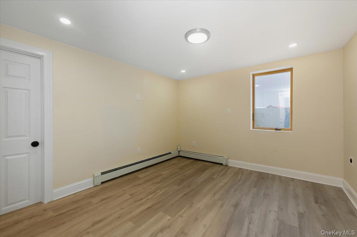 66 Elm Street Valley Stream, NY 11580 - Photo 9 of 23 an empty room with wooden floor and windows