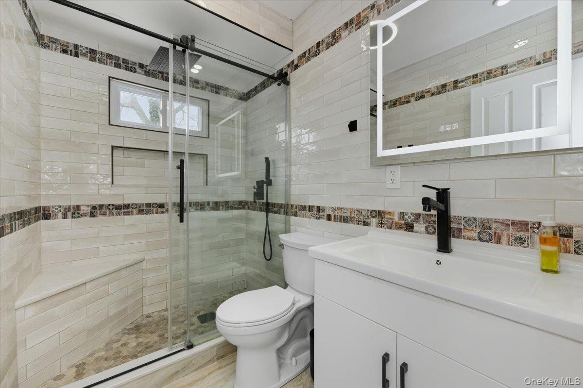 66 Elm Street Valley Stream, NY 11580 - Photo 10 of 23 a bathroom with a sink a toilet and shower