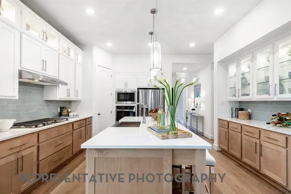 a kitchen with stainless steel appliances kitchen island granite countertop a sink a stove and cabinets