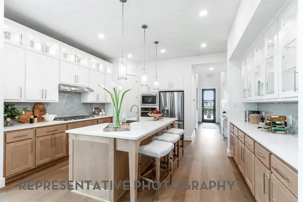 a kitchen with stainless steel appliances kitchen island granite countertop a lot of counter space and wooden floors