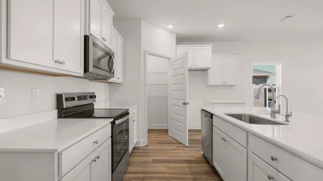 a kitchen with cabinets stainless steel appliances a sink and a stove