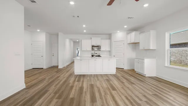 a kitchen with cabinets stainless steel appliances and wooden floor
