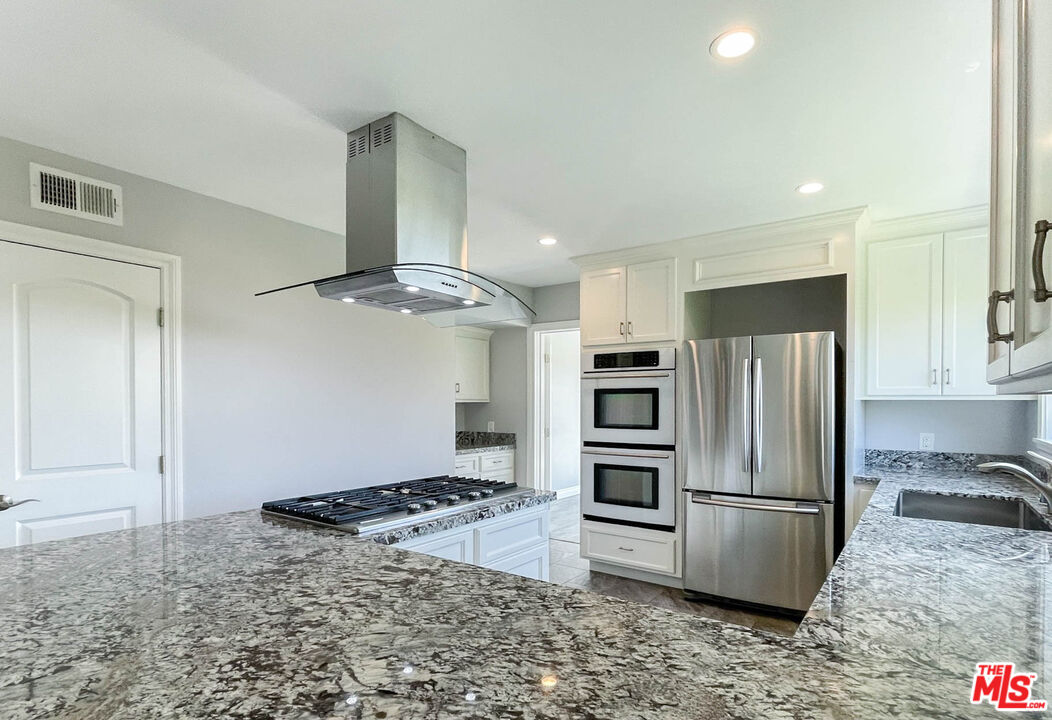 3824 Surfwood Road Malibu, CA 90265 - Photo 12 of 36 a kitchen with stainless steel appliances granite countertop a refrigerator and a stove top oven
