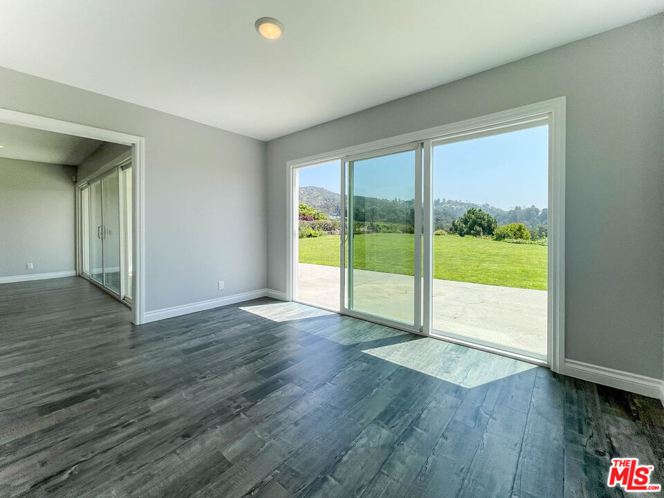 3824 Surfwood Road Malibu, CA 90265 - Photo 13 of 36 a view of an empty room with wooden floor and a window