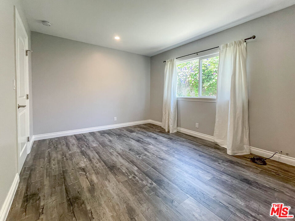 3824 Surfwood Road Malibu, CA 90265 - Photo 16 of 36 an empty room with wooden floor and windows